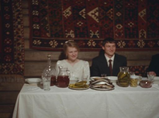 Seedance 2.5: Old Soviet VHS home video footage, early 1990s Russia, rural wedding celebration. A couple sitting at a long table cover